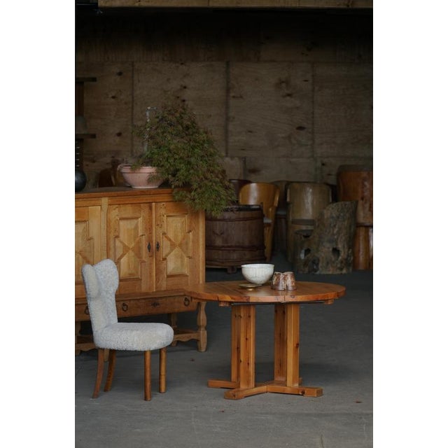 A charming Danish Modern round dining table crafted in solid pine, produced in Denmark during the 1970s. The table...