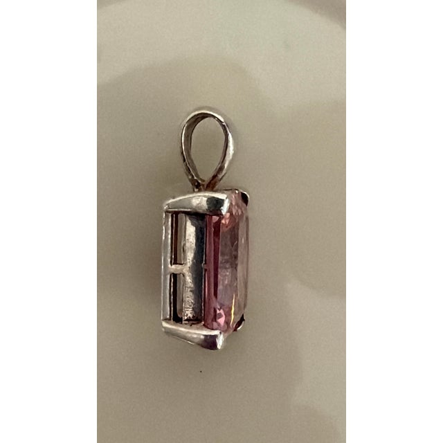 Cut: Elongated radiant or emerald cut with corner facets. Setting: Simple four-prong minimalist basket setting designed to...