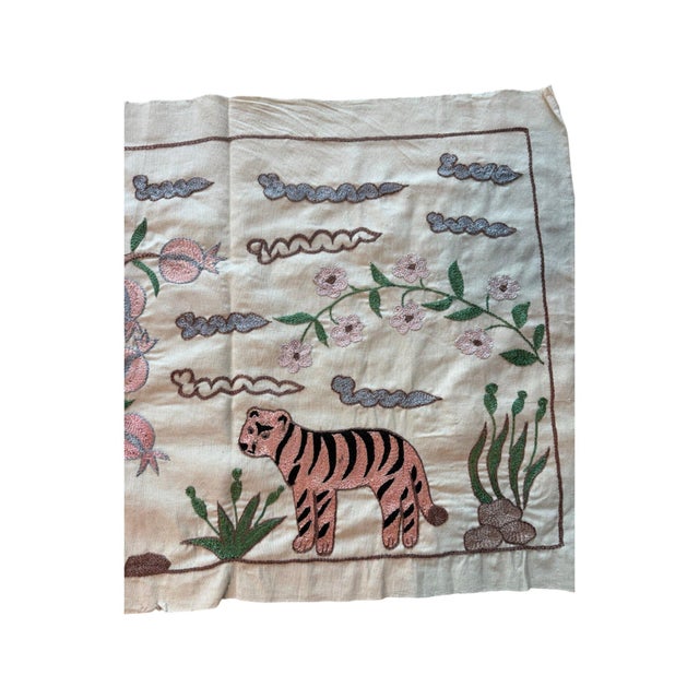 Hand-embroidered Suzani panel from Uzbekistan, worked in fine floss on a cream cotton ground. Three tigers move across the...