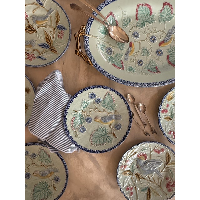 This is a nine-piece Pottery Barn majolica-style collection featuring richly embossed birds, branches, and berries in a...