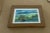 A beautifully atmospheric original watercolor landscape featuring rolling green hills, secluded country buildings, and a...