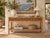 Beautiful vintage coastal rattan console table featuring a natural honey-toned finish, decorative wavy rattan detailing,...