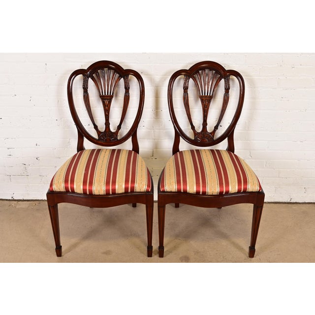 A gorgeous pair of Federal or Hepplewhite style shield back side chairs or dining chairs In the manner of Baker Furniture...