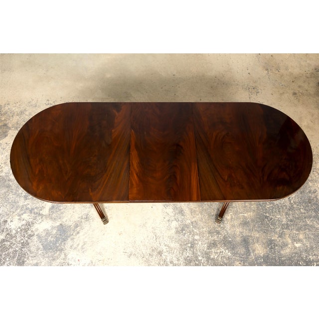 A handsome mid-20th century English Georgian-style double pedestal dining table, sourced from Provence, France. Crafted...