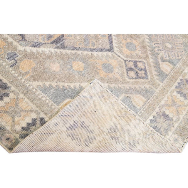 Beautiful vintage Persian distressed hand-knotted wool rug with a gray color field. This piece has a beige frame and brown...