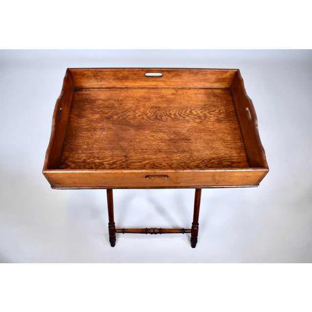 A 19th-century English Tiger oak butler tray table, Georgian in style, with four handles tray boasting striking dovetail...