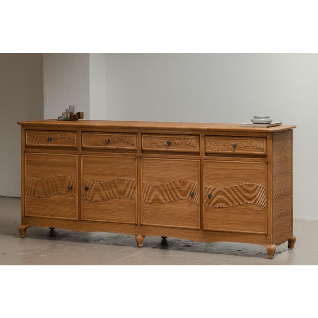 Rattan sideboard produced around 1970 in Italy. This bamboo sideboard on elegant feet has 4 doors and drawers with a...