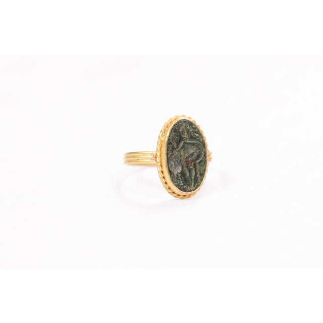 A 21 karat gold ring with a Byzantine bronze coin. This bronze coin was minted between IV and IX century, and depicts a...