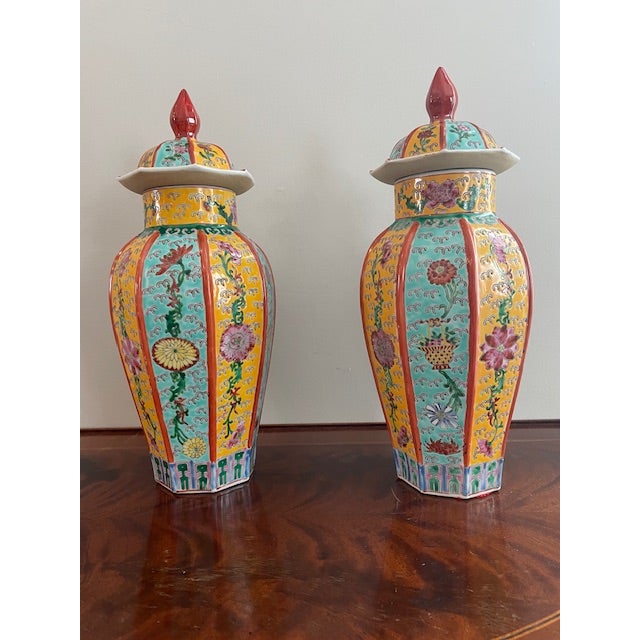 A striking pair of Chinese famille rose porcelain ginger jars with matching lids, beautifully decorated in vibrant...