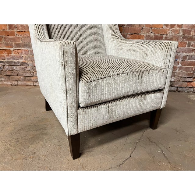 his type of chair is characterized by its classic wingback design, which includes a high back and "wings" on the sides. It...