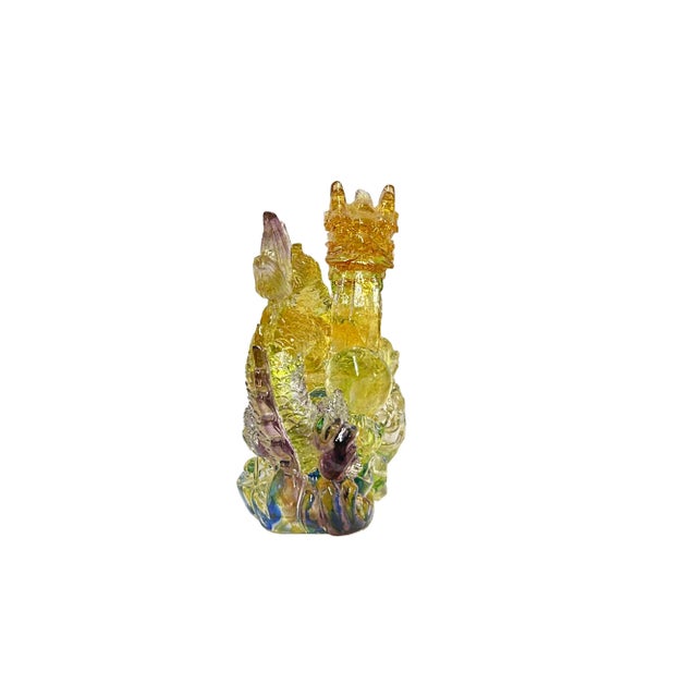 The Chinese orange yellow crystal glass dragon holding a ball riding on a wave figure is a mesmerizing piece of artistry...