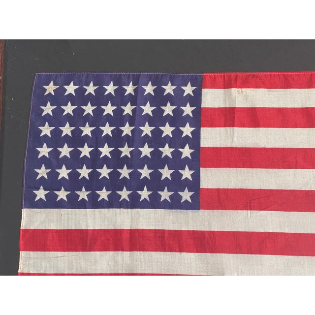 Antique American silk 48 stars flag in a folk art style frame under glass.