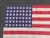 Antique American silk 48 stars flag in a folk art style frame under glass.