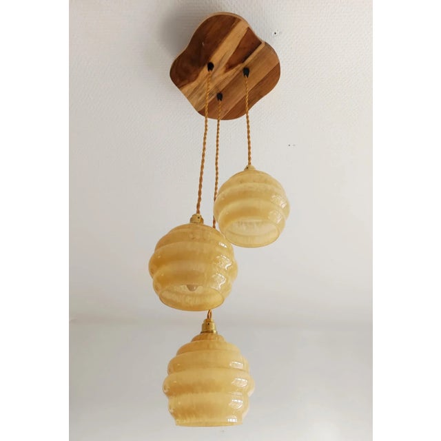 Three-light pendant light, known as a "cascade," composed of three art deco globes in honey-yellow Clichy glass. They were...
