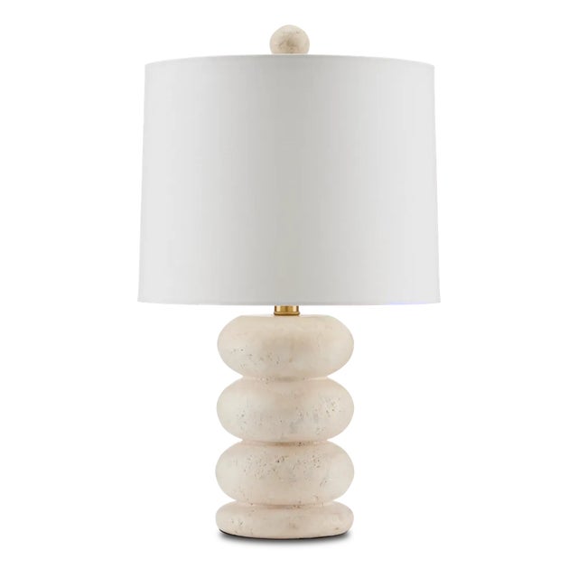 The Girault Table Lamp is carved from beige travertine, the pitting on the surface for which the material is famed...