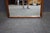 Mid-Century Modern walnut framed mirror with a clean rectangular form and stepped architectural detailing. Features a warm...