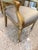 Luxurious accent armchair features a gracefully curved crest rail and open arms, all finished in warm gold leaf over...