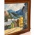Vintage landscape painting depicting a rustic mountain town set against a backdrop of alpine peaks. The composition...