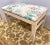 Pretty chintz upholstered bench with distressed cream finish.