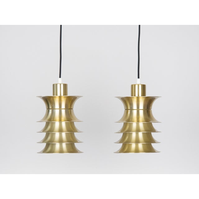 A pair of gold space-age lamps from the 1970s. The lamps are made of aluminum. Dimensions: Diameter 13cm Height 28cm The...