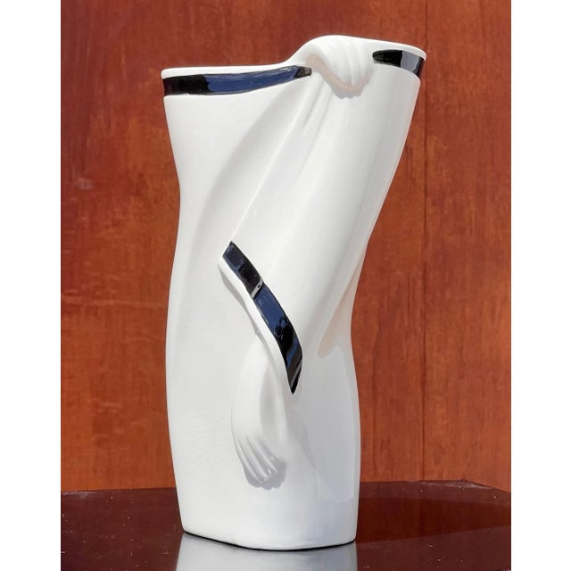 An elegant postmodern vase featuring a cloaked figure by Lindsey B., signed, 1983. Tones of snow and licorice. 5” W x...