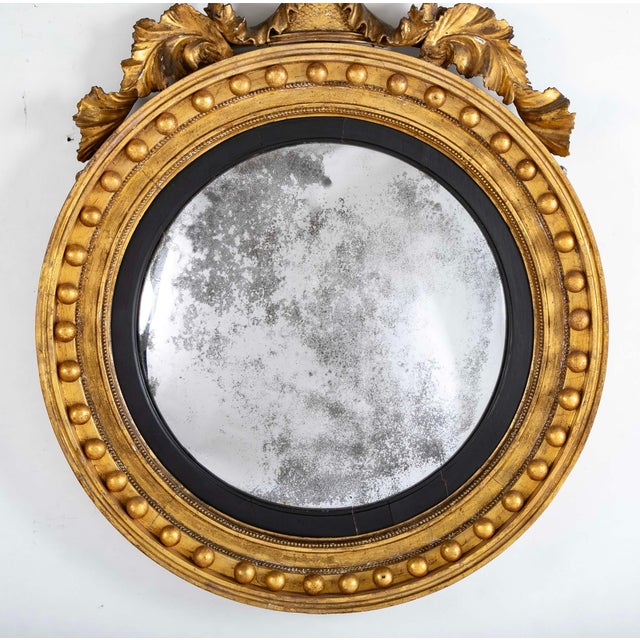 Regency Gilt Wood Convex Mirror, early 19th century. The original mirror plate within a reeded ebonised inner molding, the...
