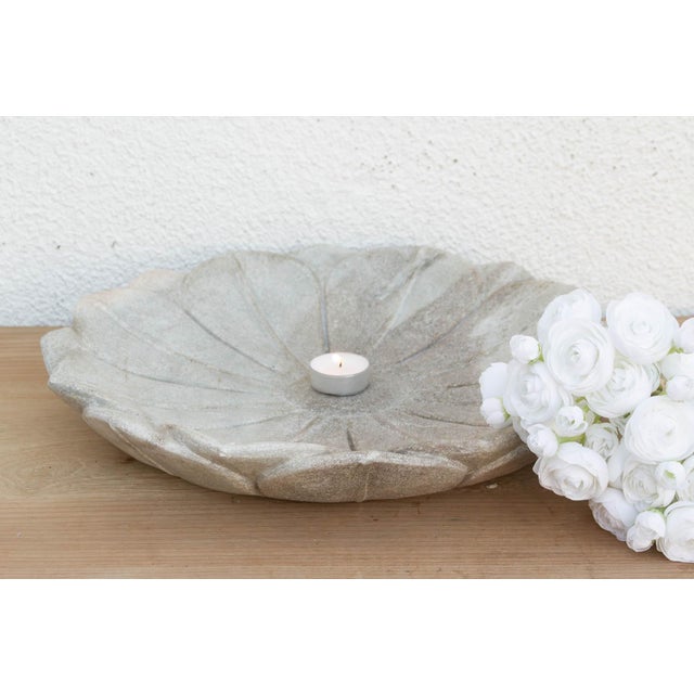 Carved from solid stone with a cool, matte grey patina, it feels like an artifact recovered from an ancient temple garden....