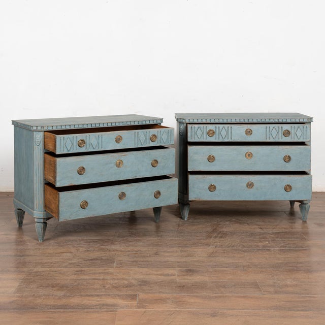 A pair of elegant Gustavian pine chest of drawers with brass pulls on each drawer. Three drawers, upper drawer decorated...