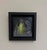 This oil painting depicts a pear nestled within crumpled plastic, creating a striking contrast between the organic form of...