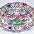 An antique hand-painted polychrome faience wall plate featuring a richly decorated composition of stylized birds, flowers,...