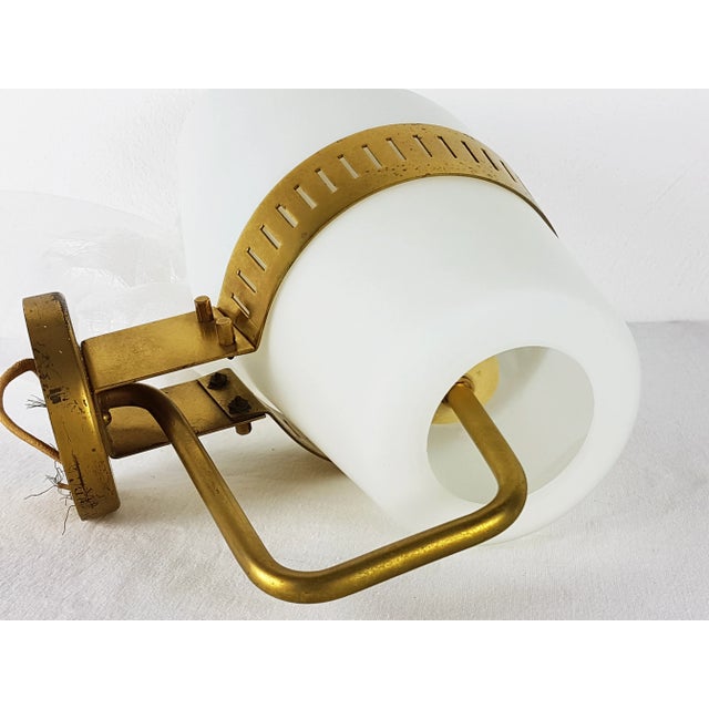 This wall lamp was produced in Italy by Stilnovo in the late 1950s. It is made from a brass structure with a white opaline...