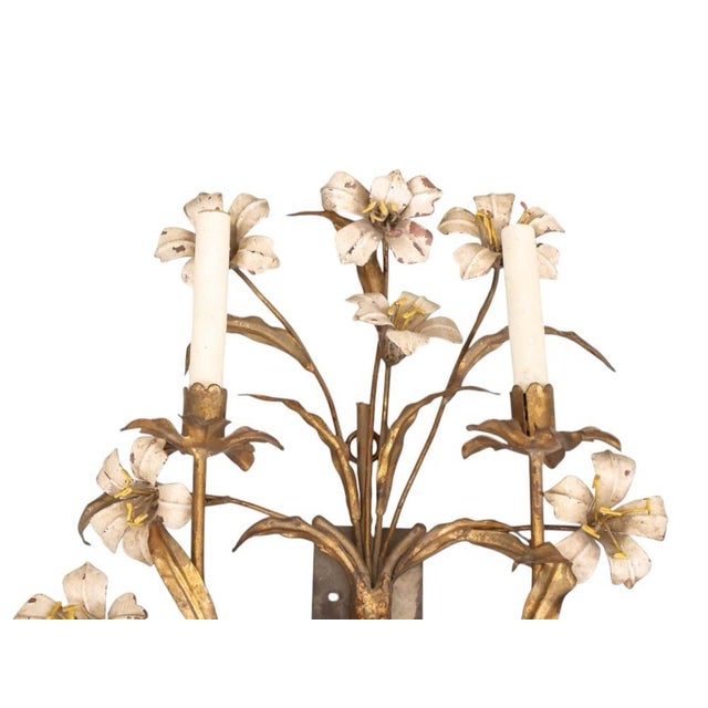 A pair of vintage French tole and brass floral five candle sconces. The pair has a weathered patina giving them rustic...