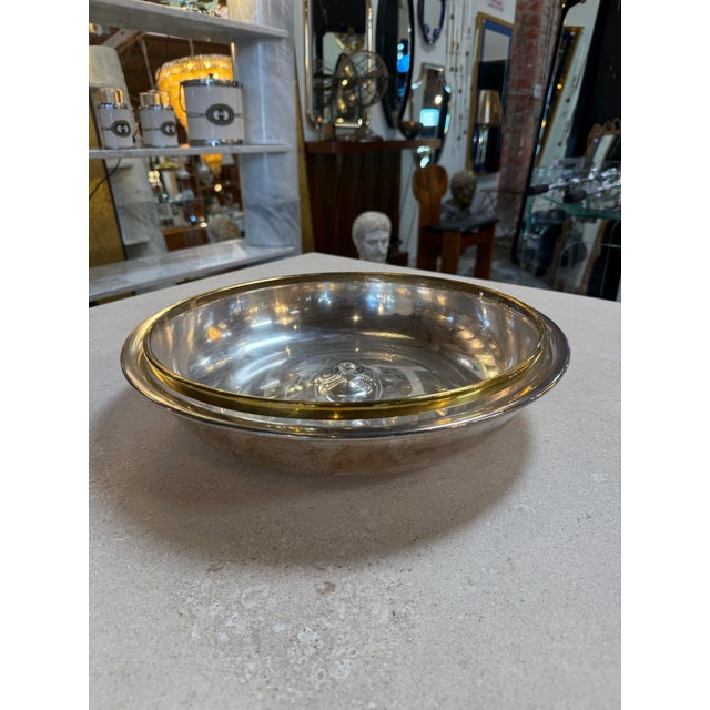 Elegant Italian serving bowl from the 1970s, composed of a polished silver-plated base paired with a removable clear glass...