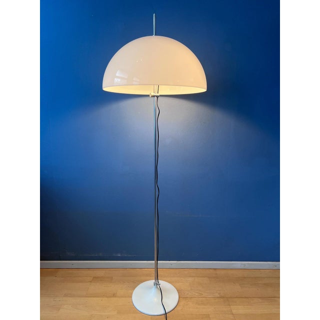 Classic vintage mid century mushroom floor lamp by gepo, featuring a white acrylic shade that emits a warm, ambient glow....