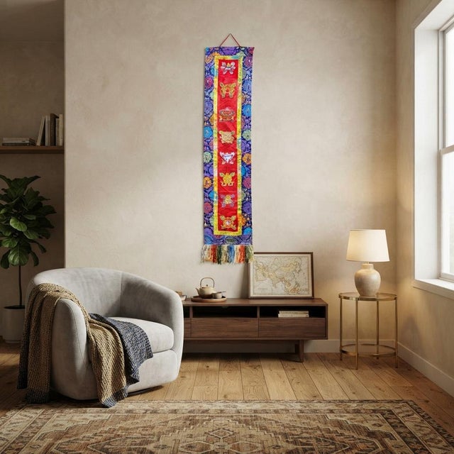 This vibrant, vertically oriented wall hanging features traditional textile craftsmanship, beautifully combining a central...