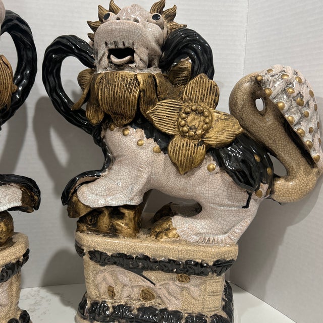 A pair of beautiful Foo dog statues, they stand 16 inches tall with a approximately 12 inches and a depth of 4.5 inches....