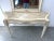 Two-piece travertine tesserae console table with matching wall mirror, dating to the 1970s. The table and mirror are clad...