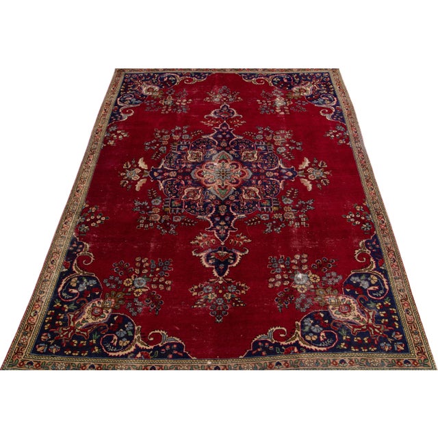 Beautiful vintage Persian Tabriz hand-knotted wool rug with a red color field. This piece has a tan frame and multicolor...