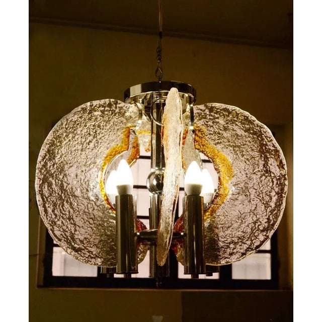- Blown glass chandelier in transparent glass with amber glass inclusion - Chromed steel structure with 6 handmade glass...
