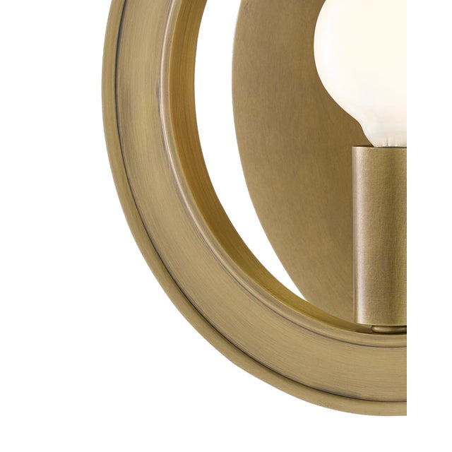 The Chaplet Brass Wall Sconce is a trickster, as it looks perfectly flat when viewed head-on but reveals its depth when...