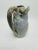 Decorative and organic, this pottery piece is a soft neutral grey with a flat finish, very primitive yet modern