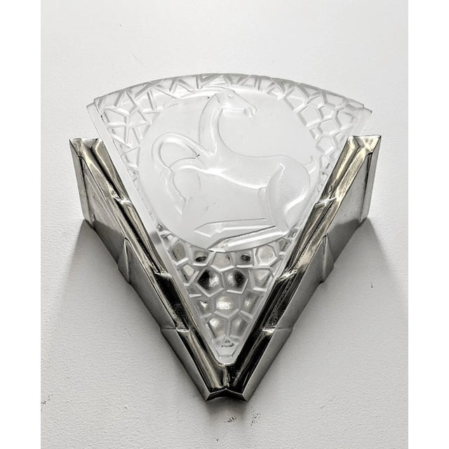 A pair of French Art Deco sconces by the French artist " Degue " in molded clear frosted glass decorated with antelope...