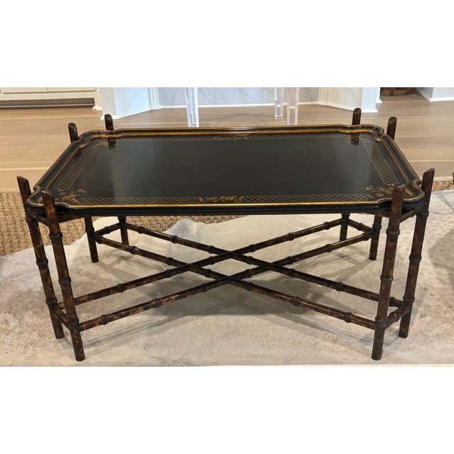 This timeless coffee table features a black lacquer tray top with hand-painted gilt chinoiserie floral and lattice...