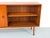 A beautifully proportioned teak sideboard with a smooth-running wooden sliding door featuring a round recessed handle....