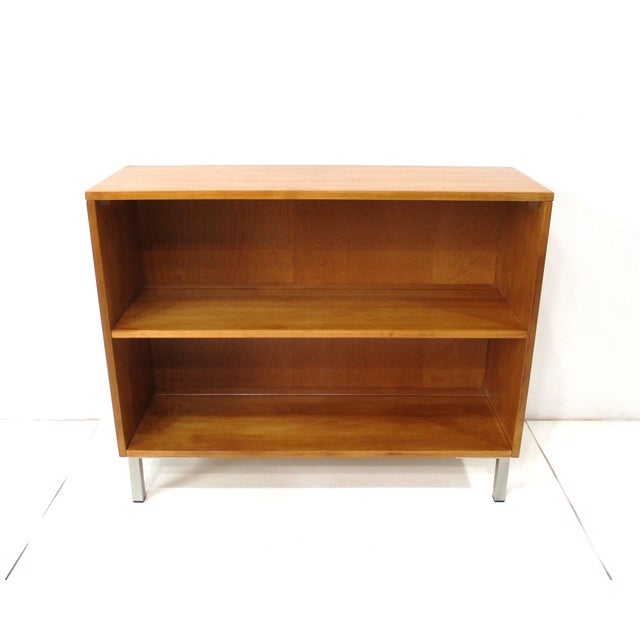 A Mid Century solid maple wood bookcase with one nonadjustable shelve sitting on square tubed stainless steel legs....