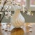 Elegant hand-blown Murano glass vase featuring ivory opaline glass with soft taupe spiral filigrana striping. The graceful...