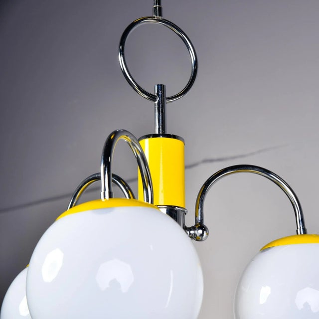 Found in Italy, this four light fixture dates from the early 1970s. Polished chrome frame with sunny yellow enamel accents...