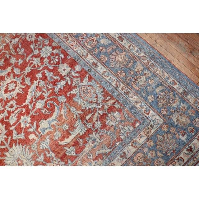 An early 20th century Persian Bibikabad oversize rug with an elegant allover design in beige, pink and gray on a soft red...