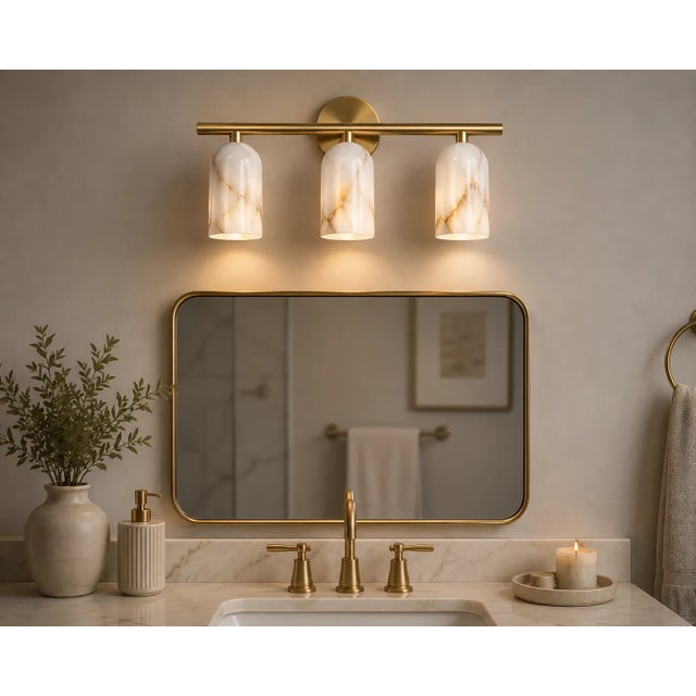Bring warmth and natural character to the wall with this handcrafted 3-light brass vanity sconce, featuring three softly...