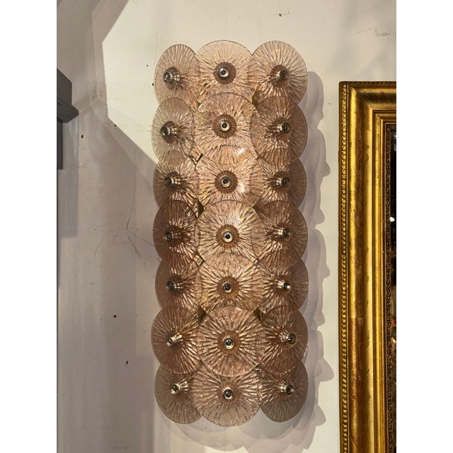 The product is a pair of Murano fume glass disc sconces,. These sconces would add a touch of elegance and uniqueness to...